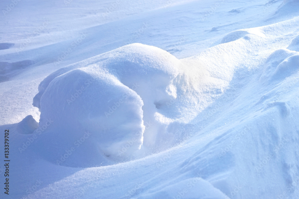 Big snowdrift outdoors in winter on sunshine and shadow. The texture bank of snow winter background 