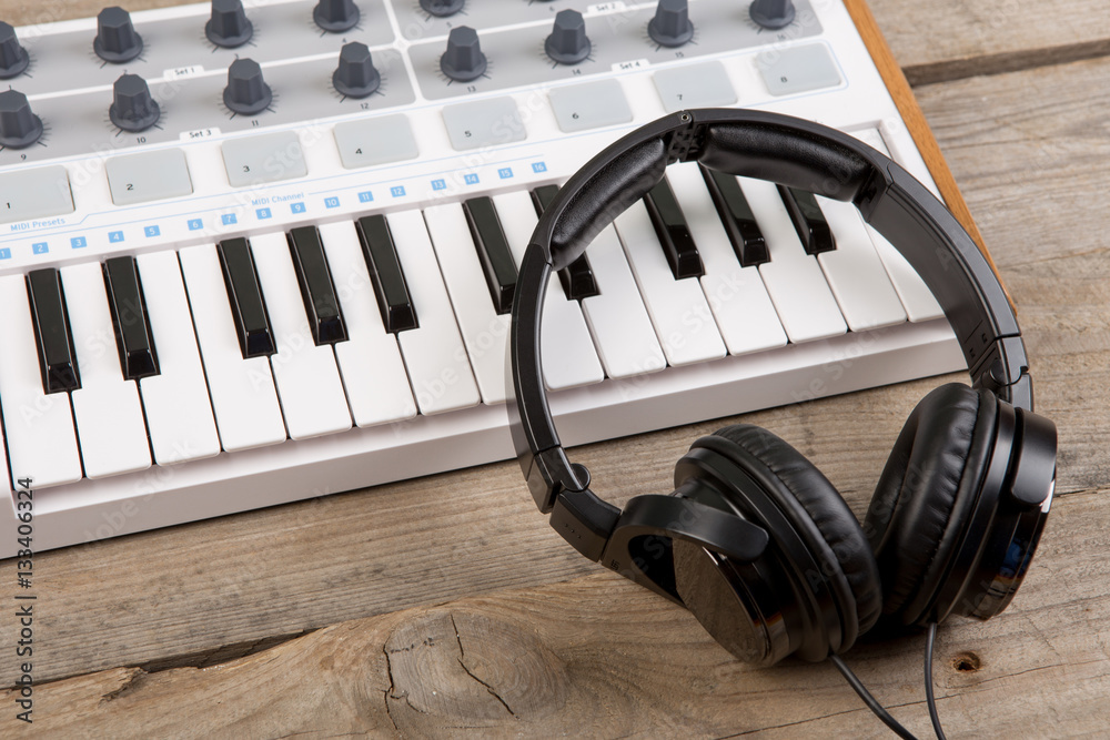 Close up of MIDI controller volume fader, knob and keys.