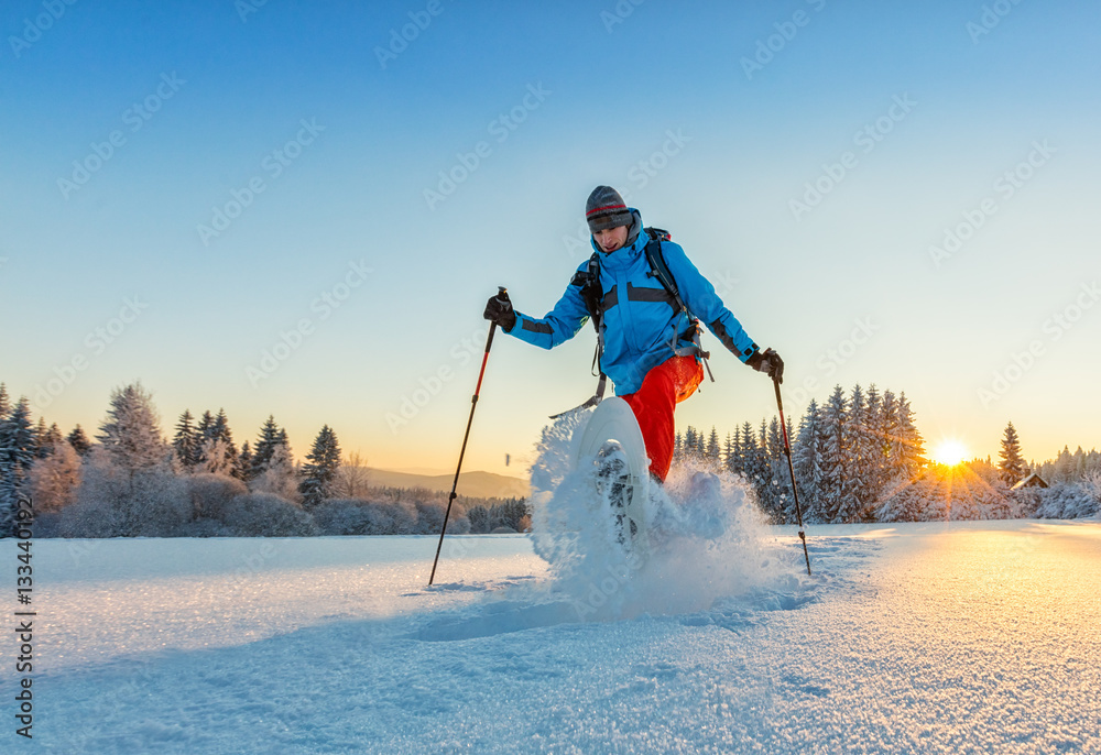 Snowshoe walker running in powder snow