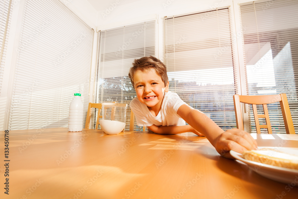 Smiling kid boy making a long arm for sandwich