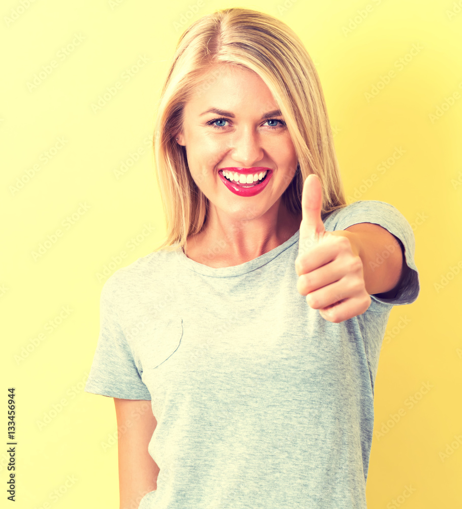 Happy young woman giving a thumbs up