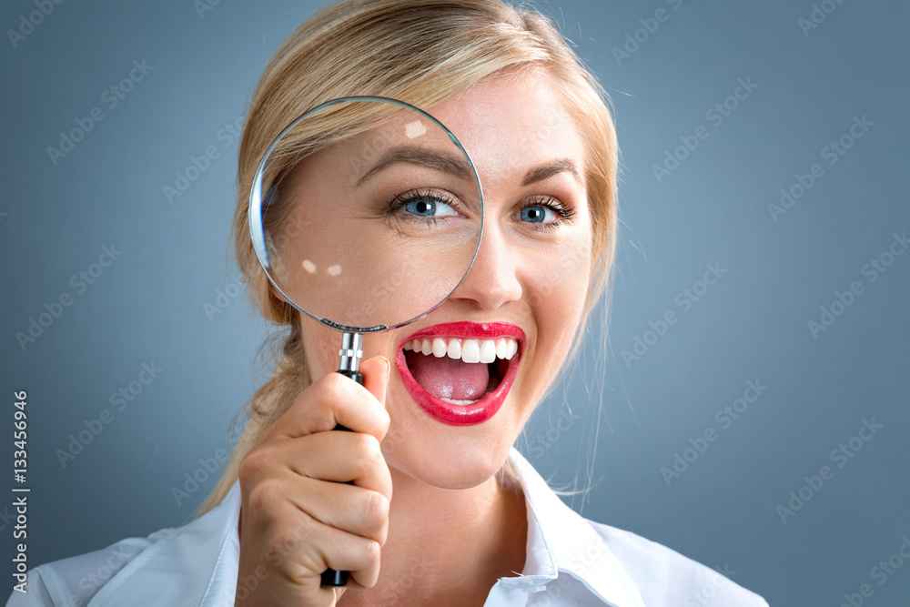 Woman looking through a magnifying glass