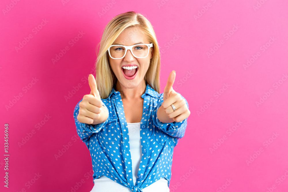 Happy young woman giving thumbs up