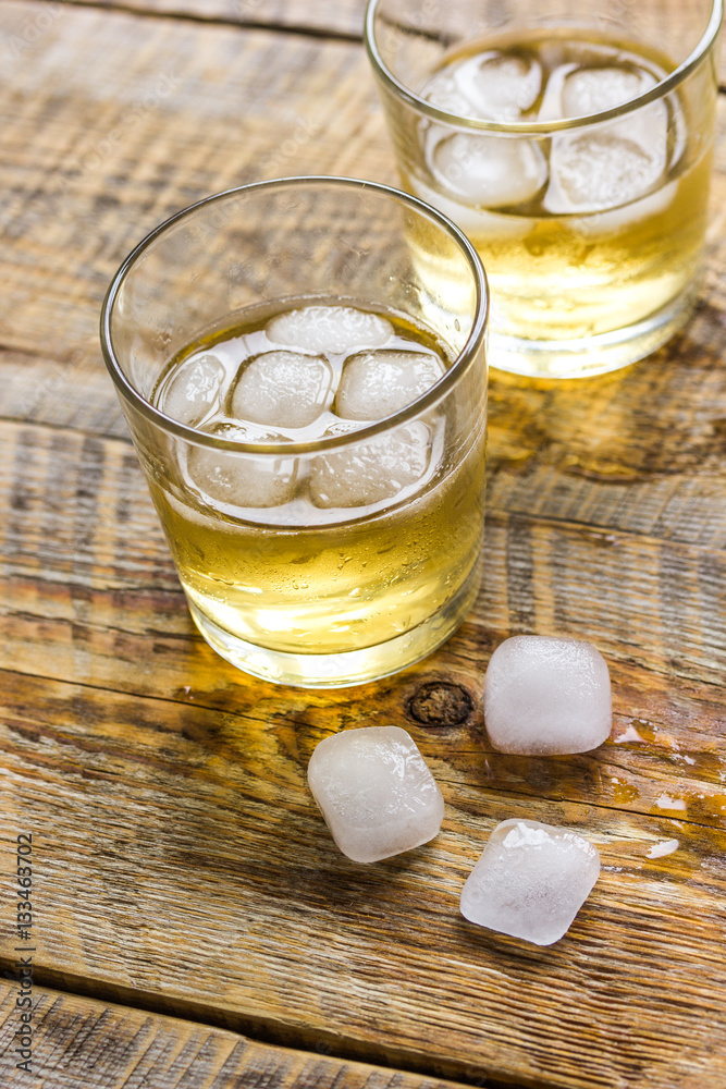 glass of whiskey on wooden background