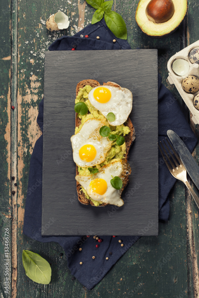 Fried egg sandwich: quail eggs, avocado and cheese on whole whea