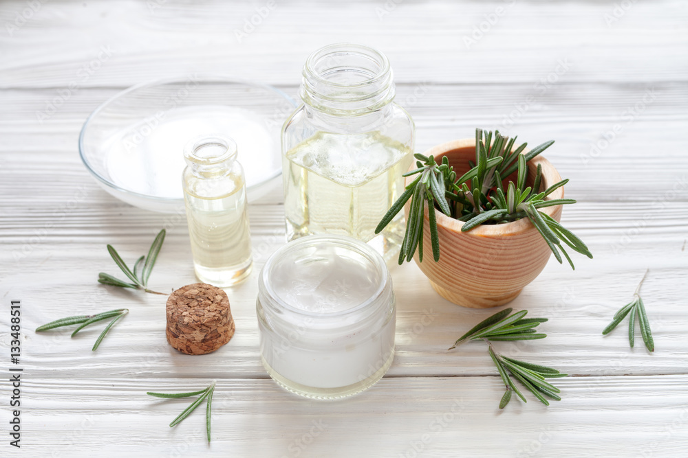 organic cosmetics with extracts of herbs rosemary on wooden background