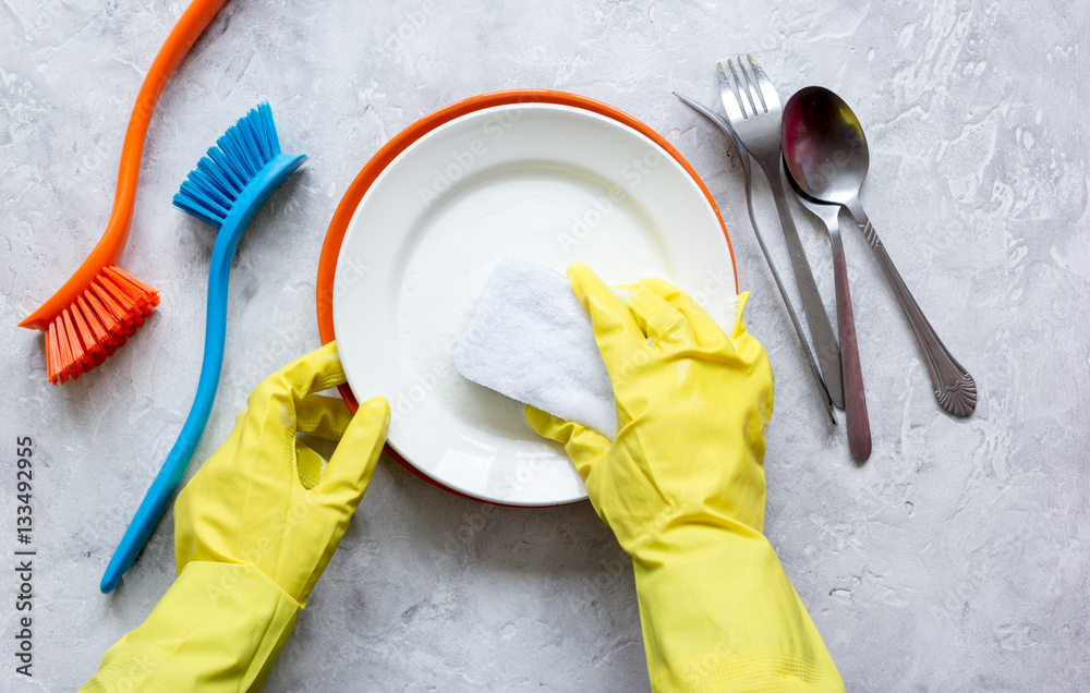 concept of woman washing dishes on gray background top view