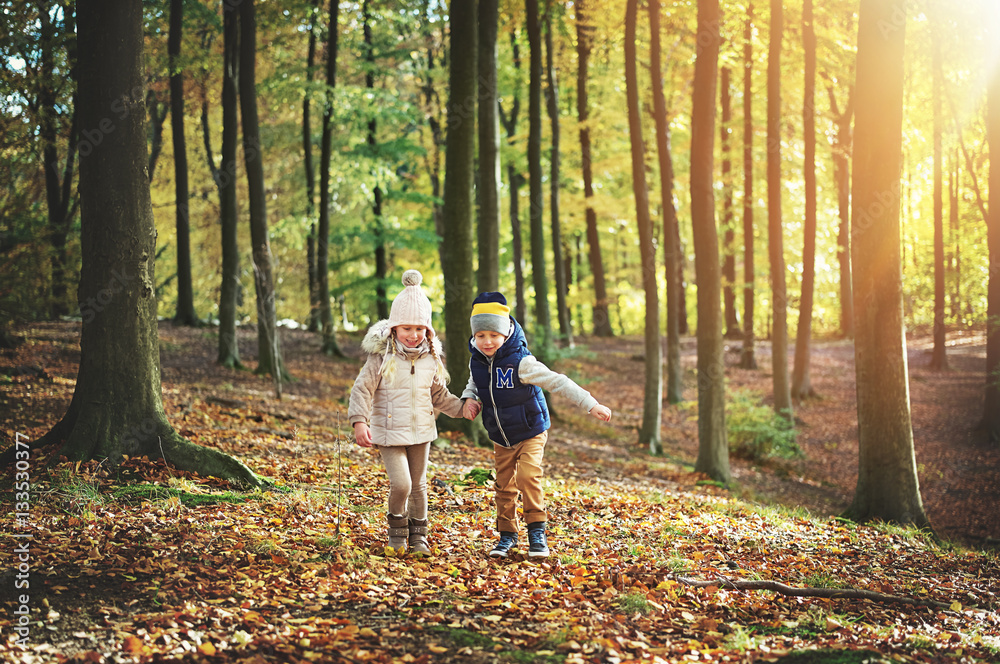 Two kids walking through the green forest