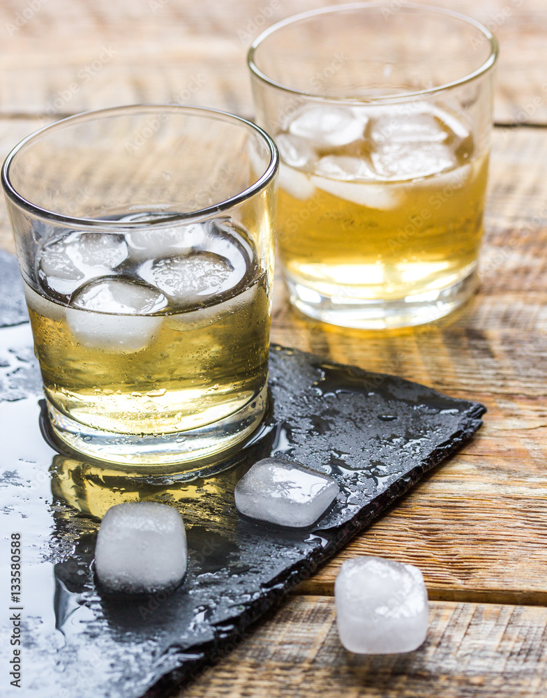 glass of whiskey on wooden background