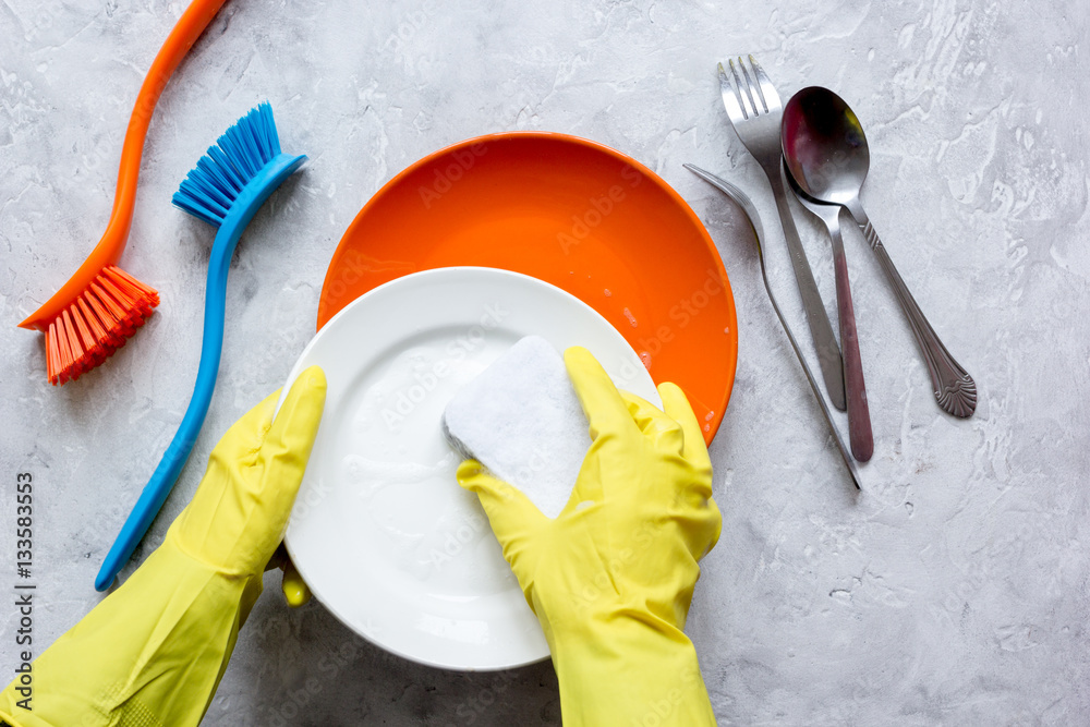 concept of woman washing dishes on gray background top view