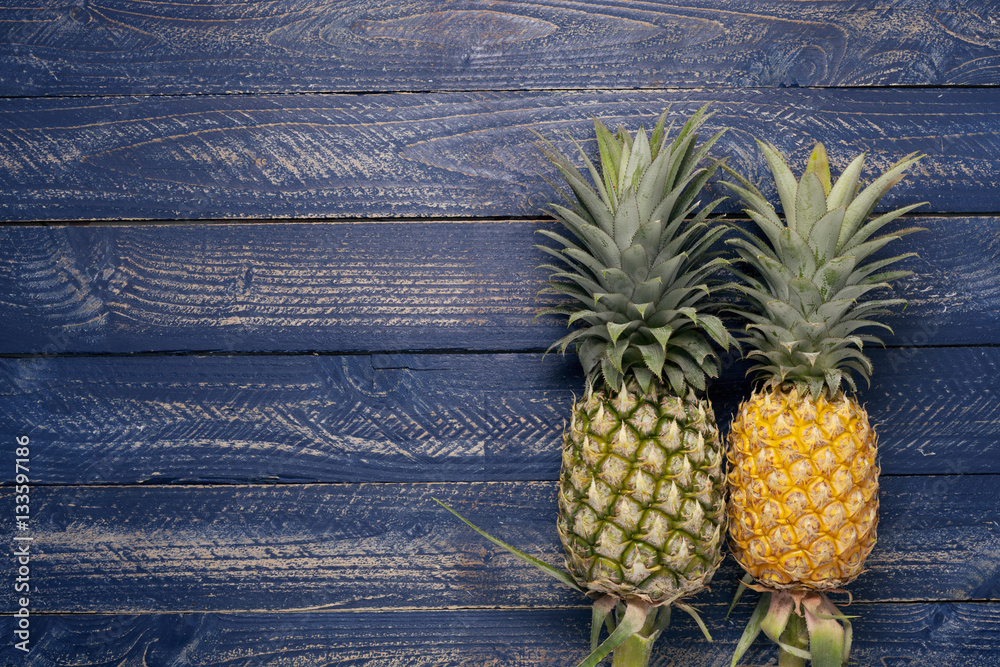 pineapple fruits on blue wooden floor background.