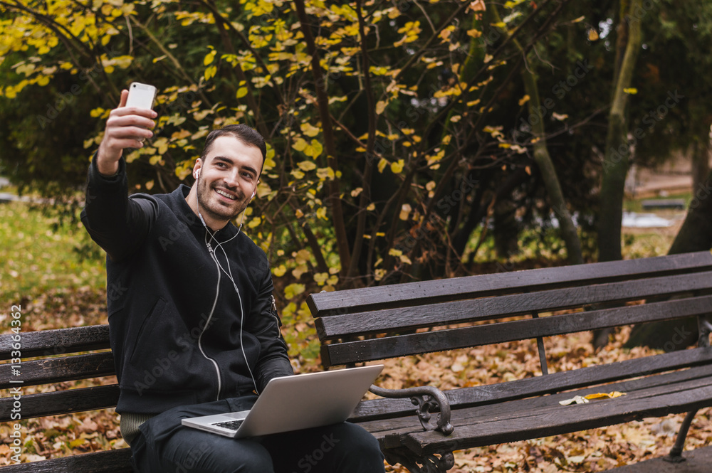 Man taking a selfie and smiling while working in the park