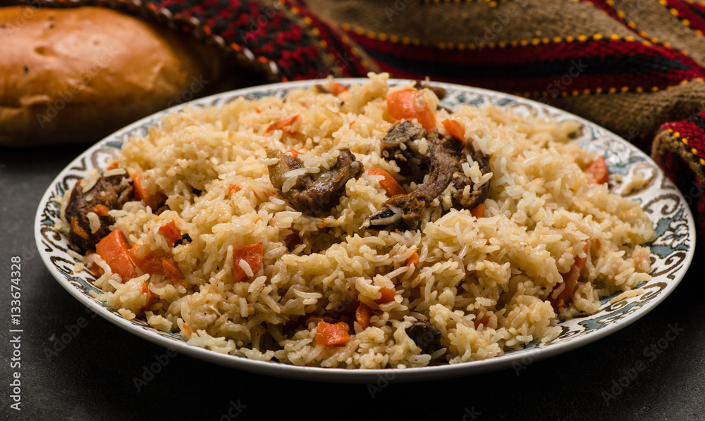 Pilaf on plate with oriental ornament and Traditional Asian breads - churek. Plov.