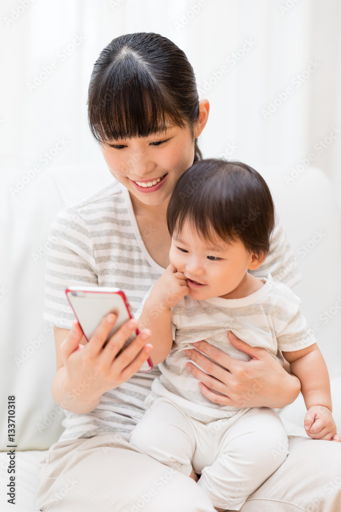 asian mother and baby using smart phone