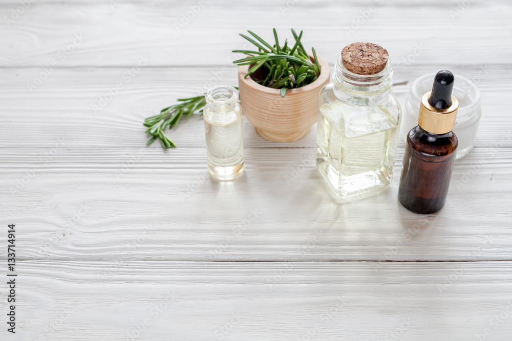 organic cosmetics with extracts of herbs rosemary on wooden background