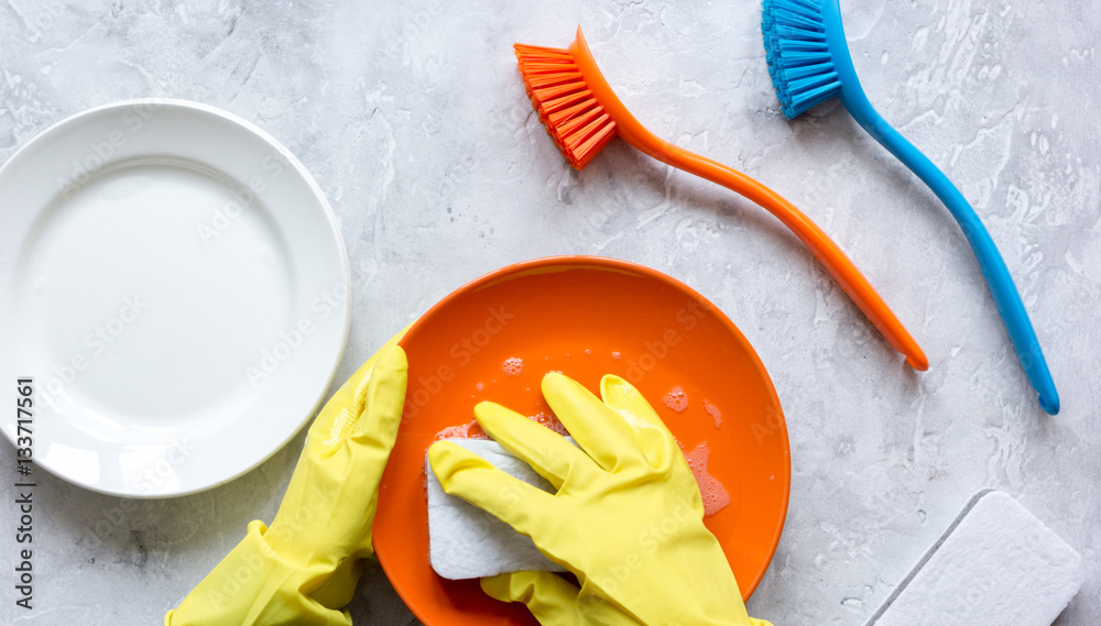 concept of woman washing dishes on gray background top view