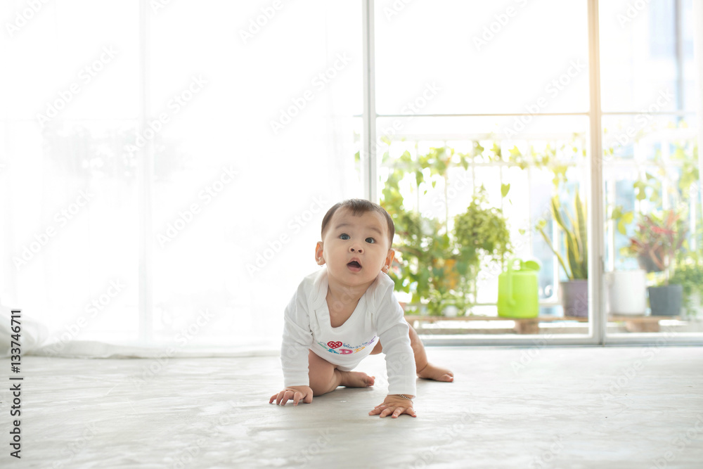 漂亮的小女婴在家里的地板上爬行