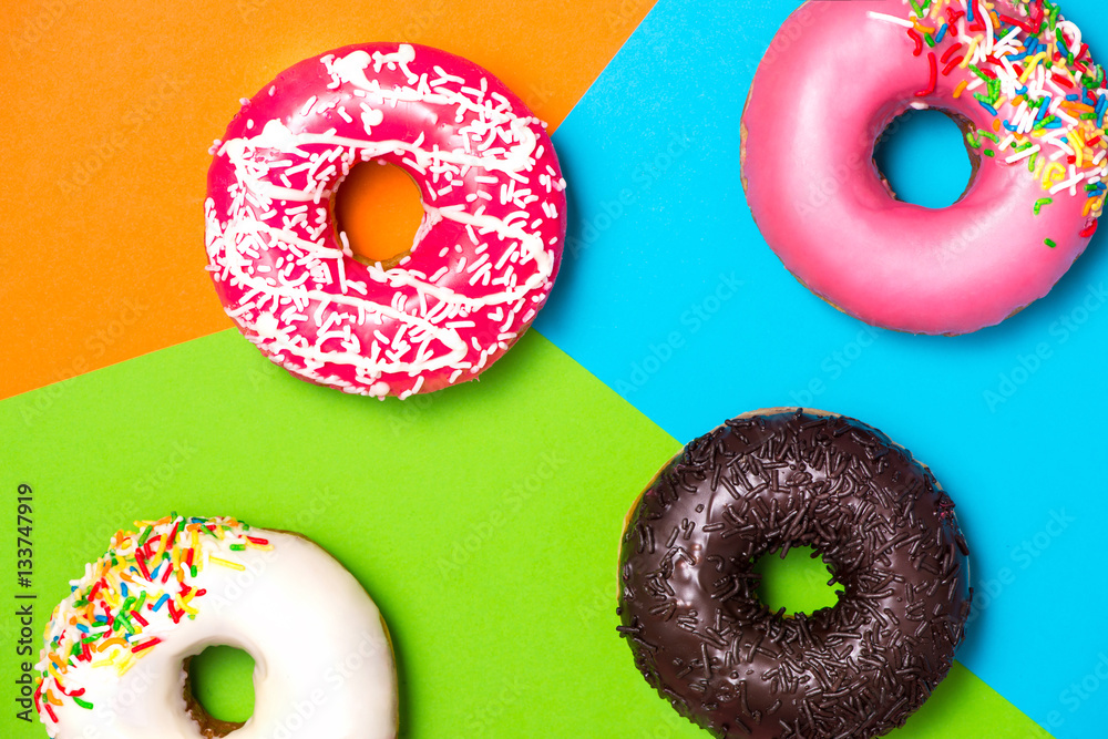 Donuts with icing on colorblock background. Sweet donuts.