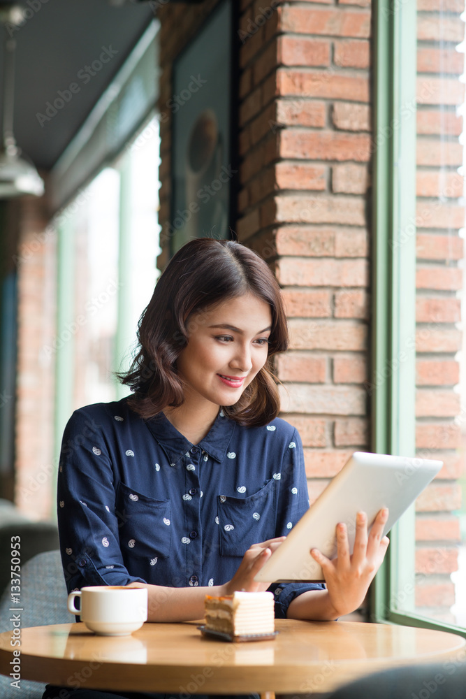 Beautiful cute asian young businesswoman in the cafe, using digi