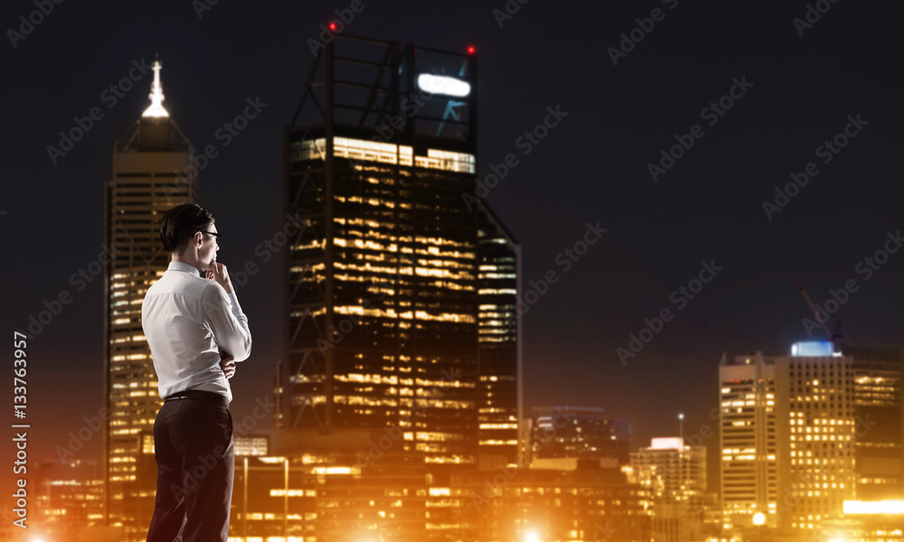 Businessman viewing night glowing city