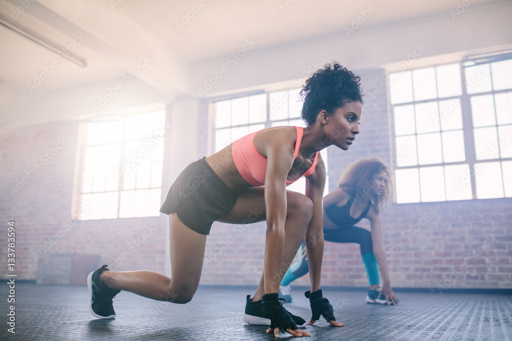 Young women doing workout together in gym.