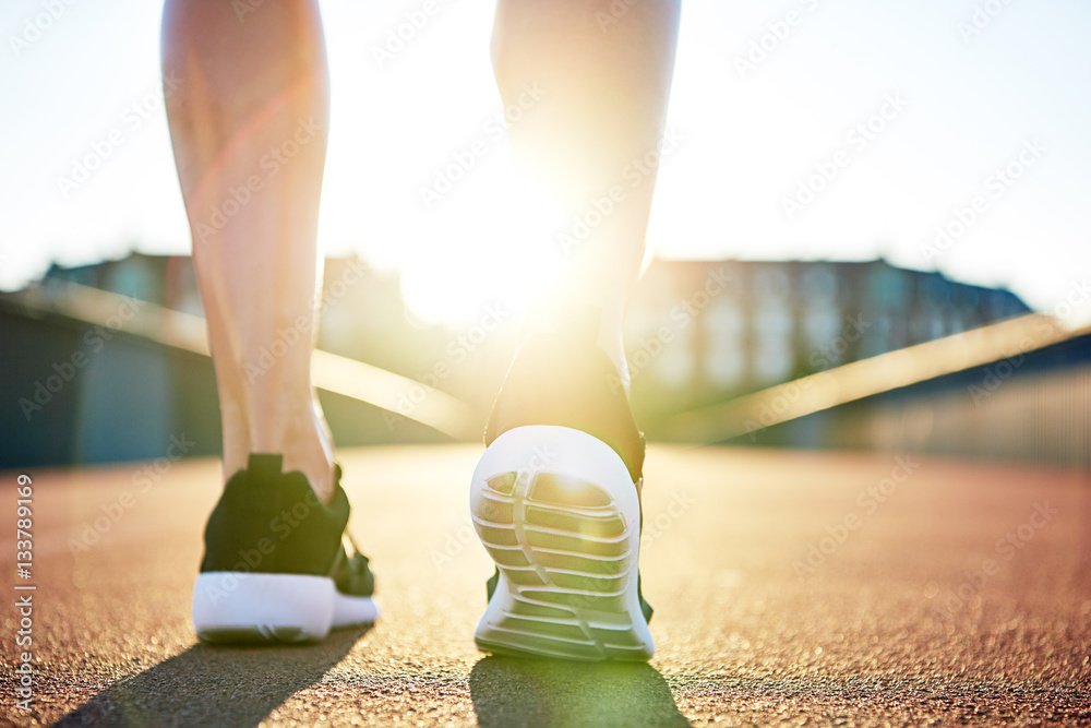 Athlete preparing to run down empty road