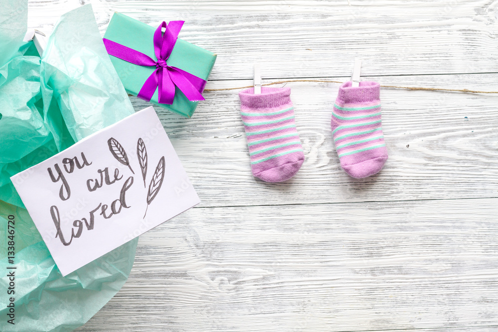 babys bootees and gift box on wooden background