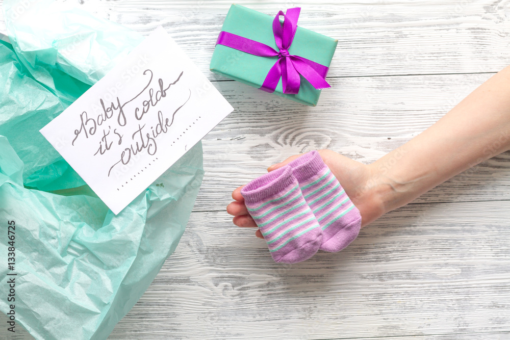 babys bootees and gift box on wooden background