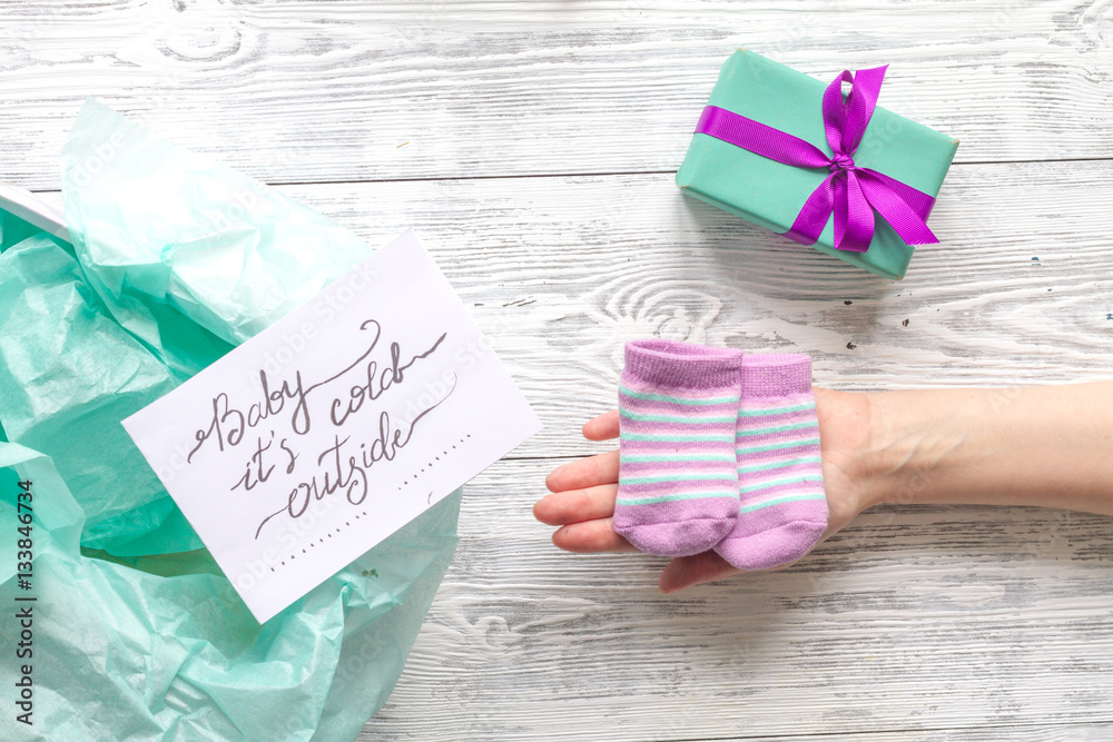 babys bootees and gift box on wooden background