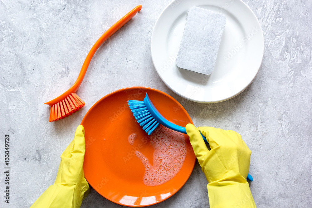 concept of woman washing dishes on gray background top view