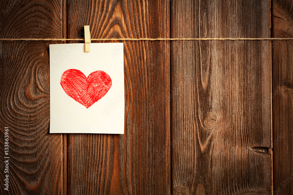 Card to day of St. Valentine and red heart on wooden