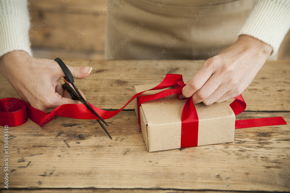 The woman is wearing a ribbon in the present box