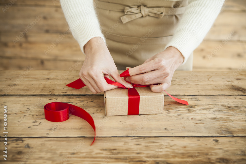 The woman is wearing a ribbon in the present box