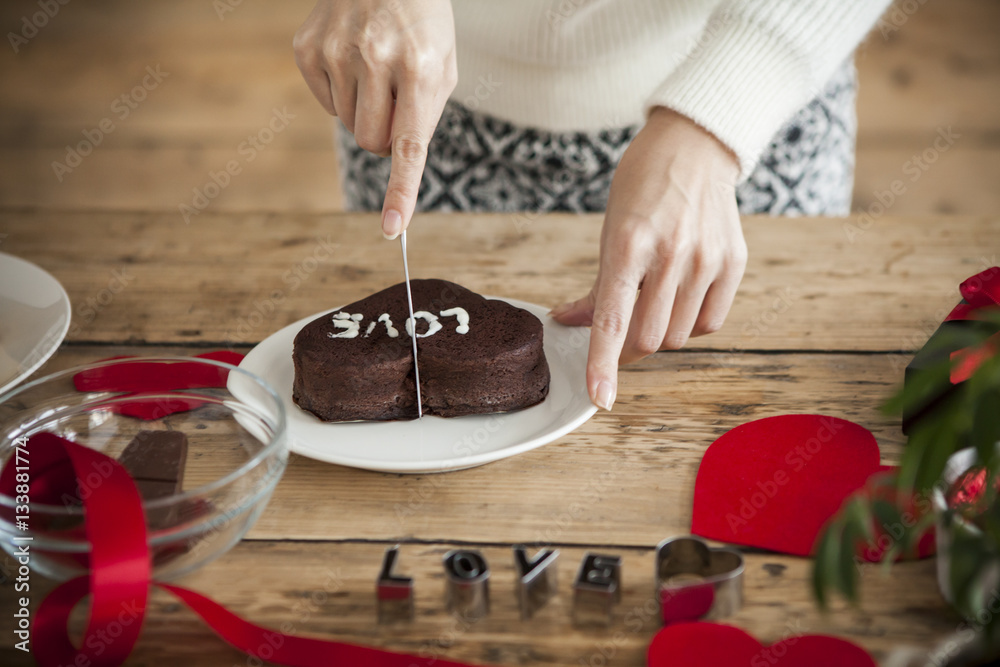 woman is cutting a chocolate cake