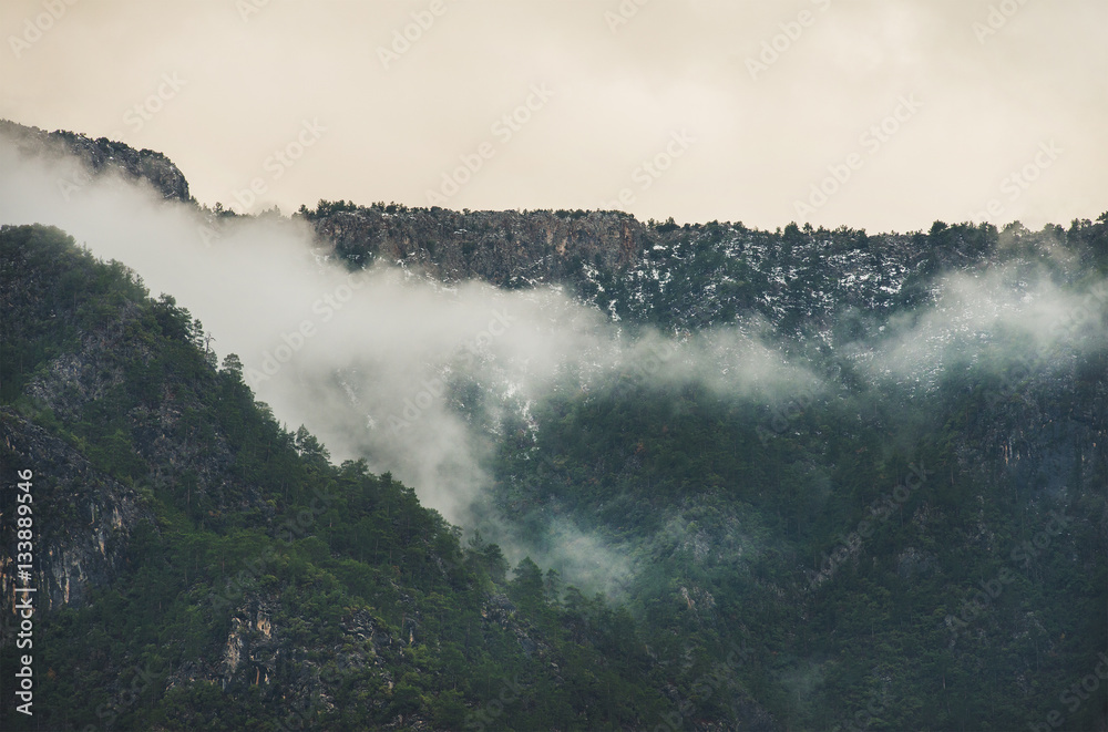 Green slopes of the Taurus mountains covered with snow and clouds in winter. Southern Turkey, Alanya