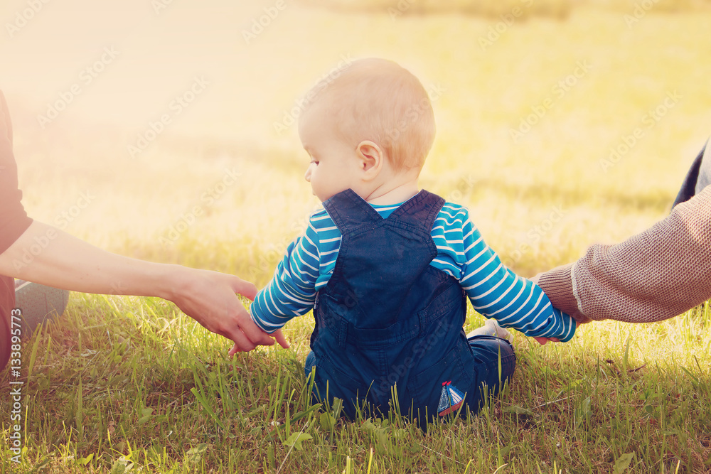 Baby with mother and father holding hands