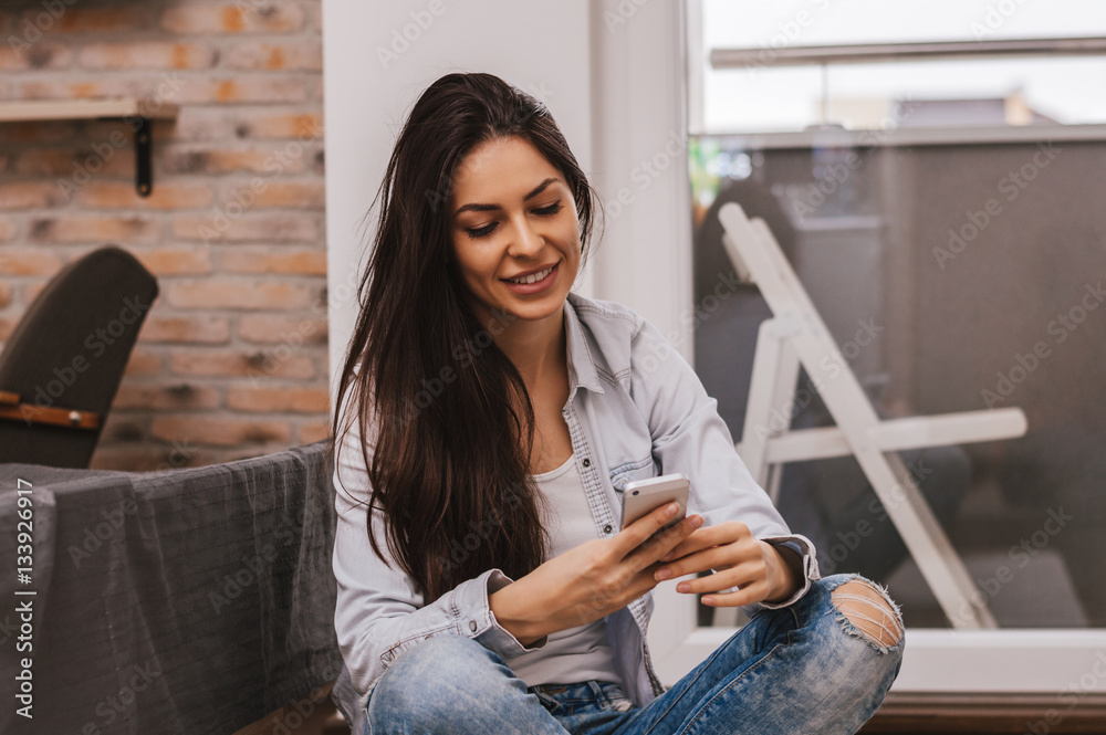 Pretty girl using her smartphone at home