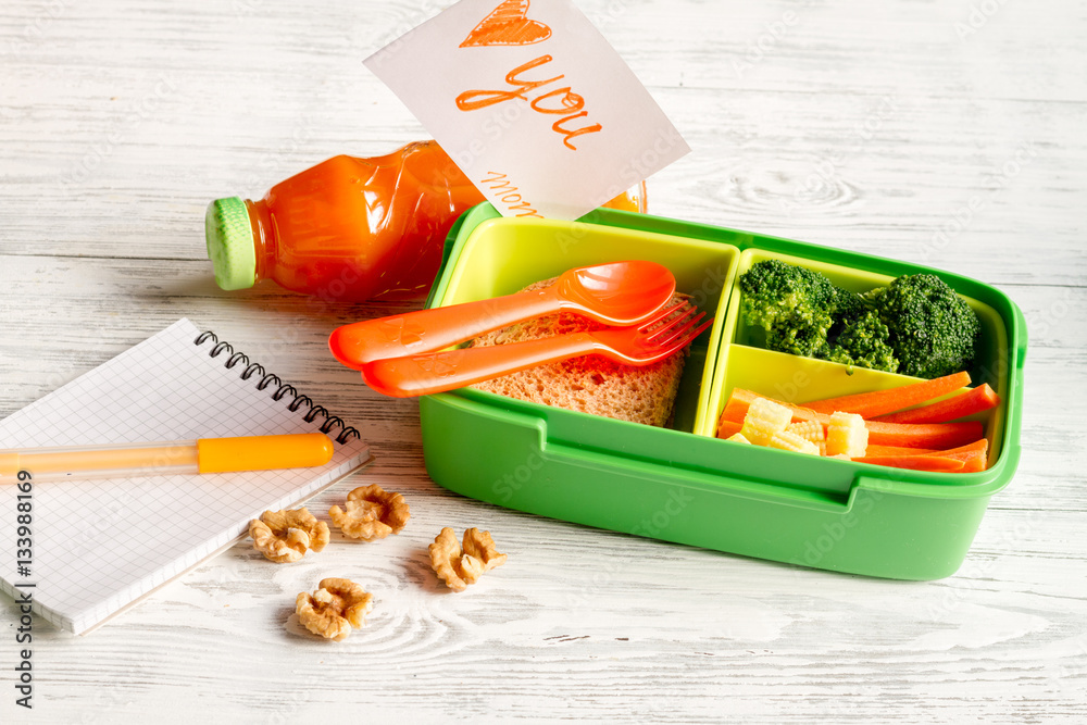 lunch box for kid with fresh vegetables on wooden background