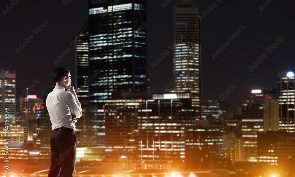 Businessman viewing night glowing city