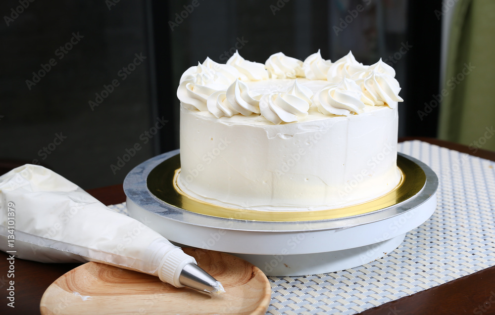 Cake in process on stand on wooden table, Homemade Cake.