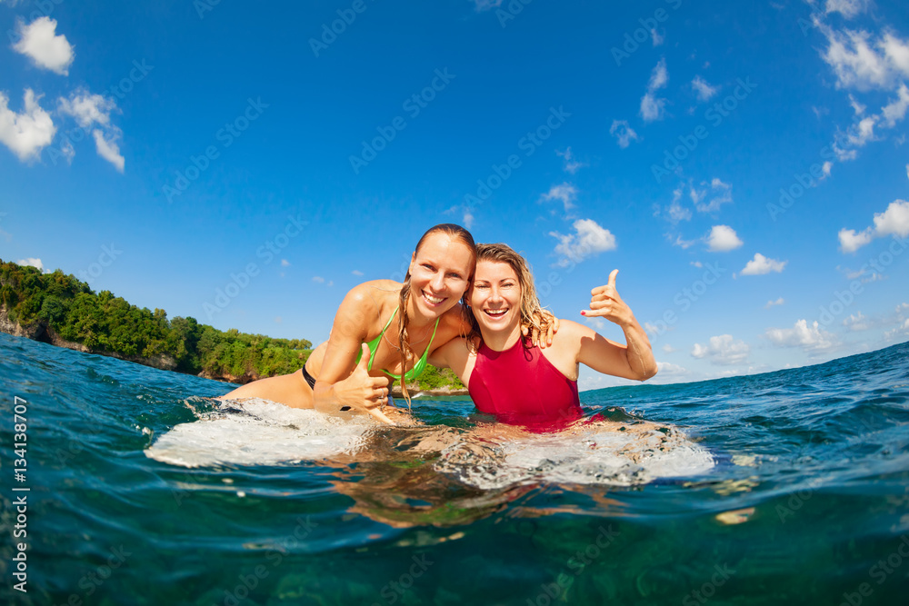 Active girl in bikini in action. Surfer woman with surf board dive underwater under breaking big wav