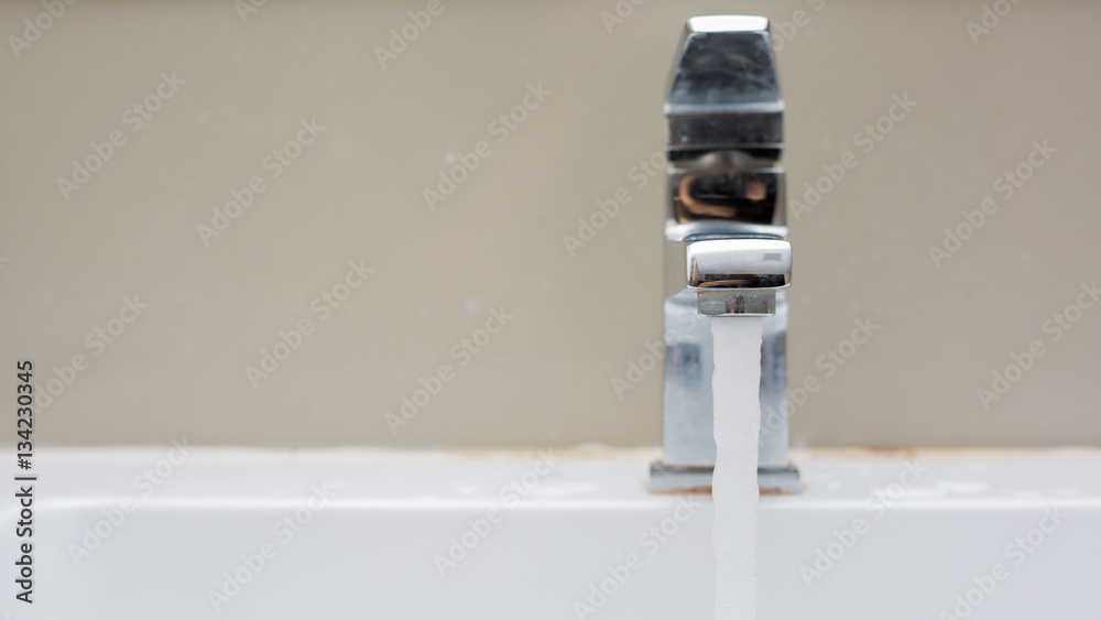 Silver faucet in bathroom,flow of water from faucet