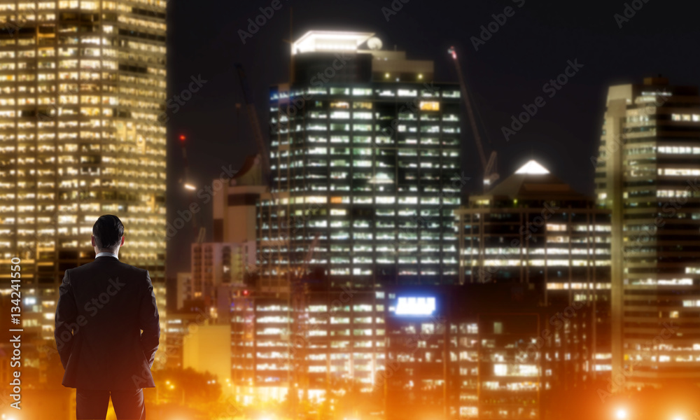 Businessman viewing night glowing city