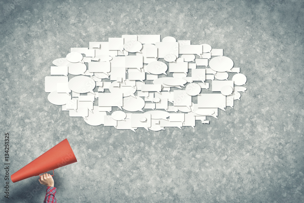 Hand of woman holding red paper trumpet and speech cloud