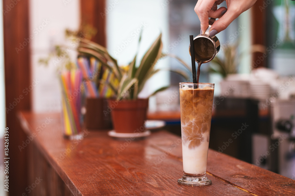 Ice coffee in a tall glass. Milk and coffee.