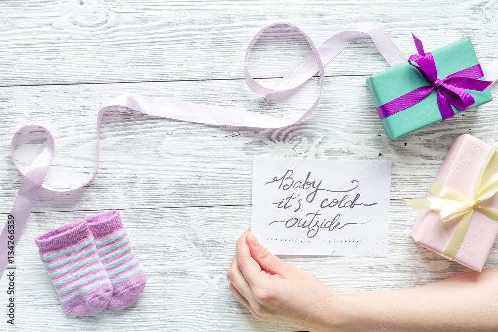 babys bootees and gift box on wooden background