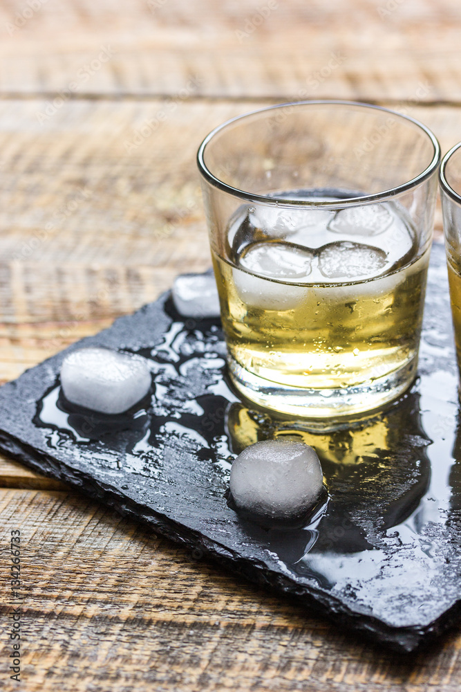 glass of whiskey on wooden background