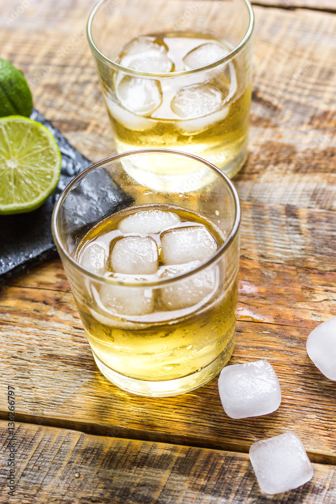 glass of whiskey on wooden background