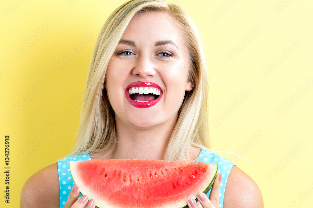 Happy young woman holding watermelon