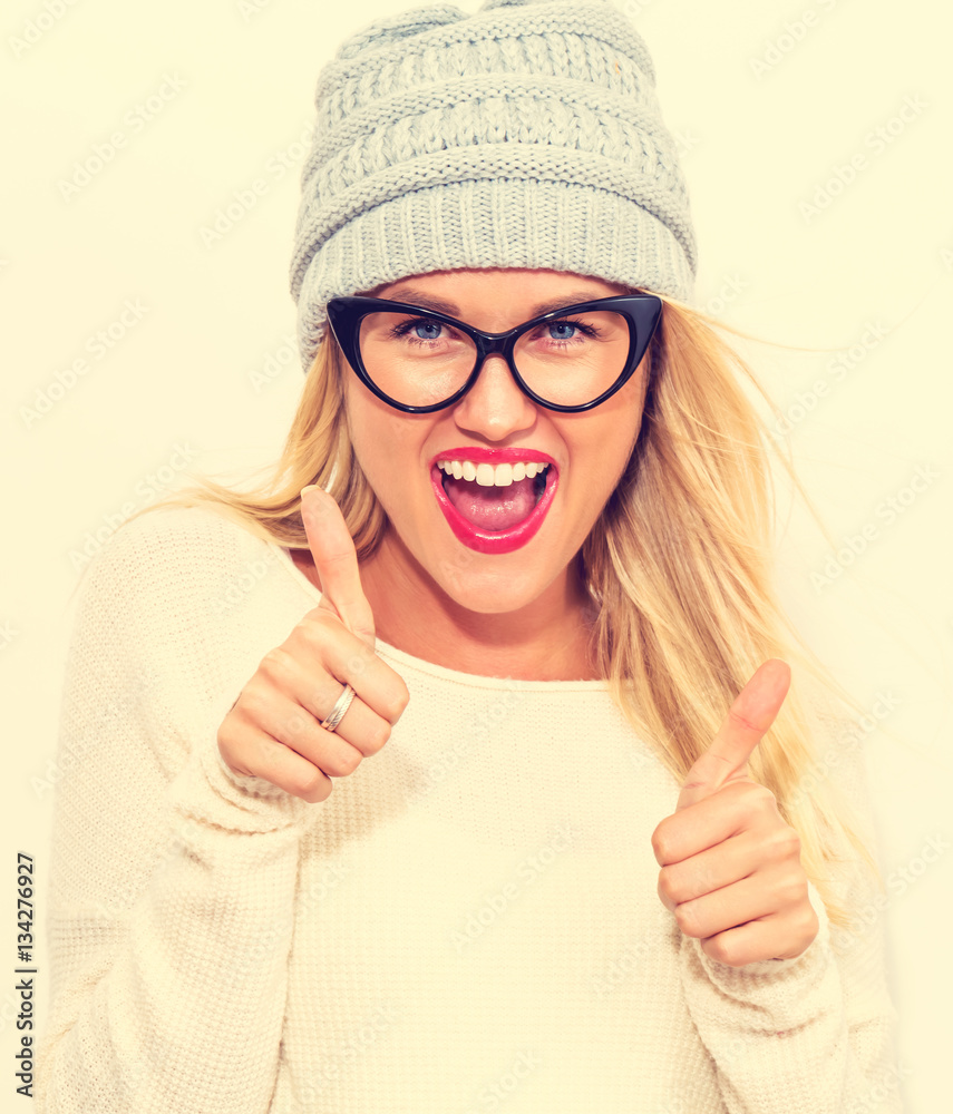 Happy young woman giving thumbs up